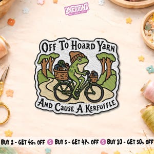 May include: An embroidered patch featuring a green frog wearing a brown beanie, riding a bicycle on a path between trees. The frog carries baskets of yarn. The text reads: Off To Hoard Yarn And Cause A Kerfuffle. The patch has a white background.