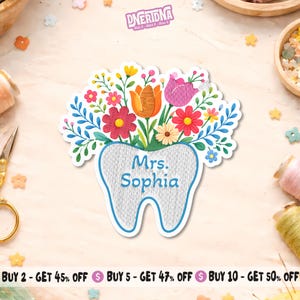 May include: A white sticker in the shape of a tooth, embroidered with the text "Mrs. Sophia" in blue. The tooth is topped with a colorful bouquet of flowers in shades of red, orange, pink, and yellow. The sticker has the brand name "DNERIDNA" at the top.