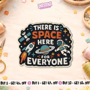 May include: A black embroidered patch featuring the white and orange text THERE IS SPACE HERE FOR EVERYONE. The design includes a white rocket with orange flames, a blue planet with rings, a white astronaut, and a satellite on a dark background.