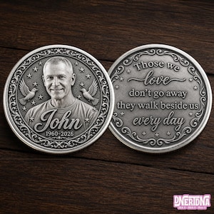May include: Two circular silver-toned commemorative coins featuring an ornate border with stars. One side displays a portrait of a man, the name John, and the dates 1960-2026. The other side features the text: Those we love don't go away they walk beside us every day.