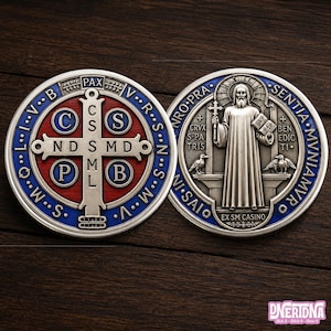 May include: Two silver Saint Benedict medals. One has a cross with letters and the word PAX. The other shows Saint Benedict holding a cross and book, with text around the edge. The medals have blue and red accents.