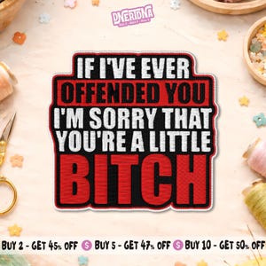 May include: A rectangular patch with the text "IF I'VE EVER OFFENDED YOU I'M SORRY THAT YOU'RE A LITTLE BITCH" in white and red lettering. The patch has a black border and is on a light-colored surface.
