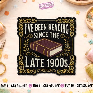 May include: A square embroidered patch with a black background and gold decorative border. It features a purple book illustration and the white text "I'VE BEEN READING SINCE THE LATE 1900s." The patch has a scalloped edge and detailed stitching.