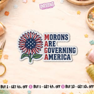 Peut inclure: Écusson brodé avec un motif de tournesol aux pétales rouges, blancs et bleus et un centre bleu. Le texte "MORONS ARE GOVERNING AMERICA" est brodé en rouge et blanc.