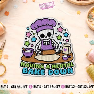 May include: Embroidered patch featuring a skeleton chef rolling dough, wearing a purple chef's hat and apron. The patch includes the text "HAVING A MENTAL BAKE DOWN" in green and blue, surrounded by colorful stars.