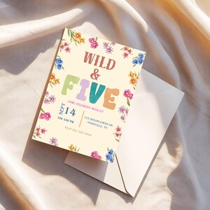 May include: A cream-coloured invitation card with the words "WILD & FIVE" in colourful letters, surrounded by floral illustrations. The card includes event details: date, time, and location. An envelope is partially visible.