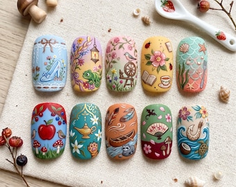 May include: A collection of ten intricately designed nail art sets, each featuring a unique fairytale-inspired theme. Designs include a glass slipper, a chameleon, a bird with a spinning wheel, and a mermaid tail. The nails are painted in vibrant colors with detailed illustrations.