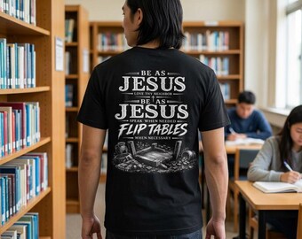 Puede incluir: Una camiseta negra con texto gráfico blanco y una ilustración en la parte posterior. El texto dice: BE AS JESUS LOVE THY NEIGHBOR BE AS JESUS SPEAK WHEN NEEDED FLIP TABLES WHEN NECESSARY. La ilustración muestra una mesa de madera volcada.