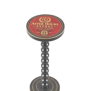 May include: A black pedestal stand with a round base and a central column of stacked spheres. The circular top features a red surface with gold text reading AFTER HOURS PATROL, NO CALLS NO REPORTS JUST RESPECT, and a central shield emblem.