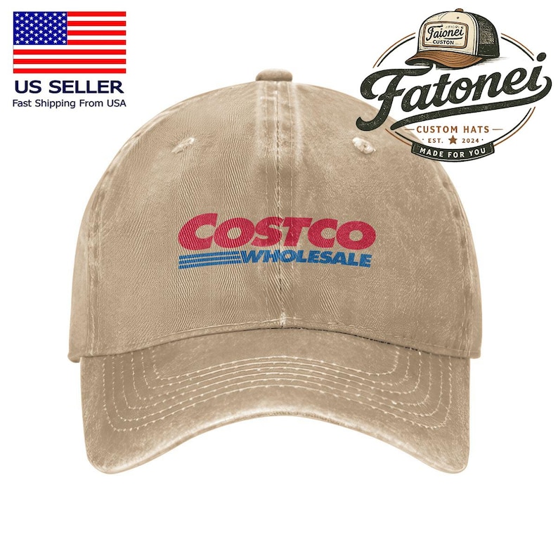以下が含まれることがあります： 赤と青のCostco Wholesaleのロゴが入ったベージュ色の野球帽。帽子はつばがカーブしており、使い古したような外観です。帽子はFatonei Custom Hats製です。
