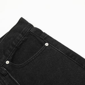 May include: A pair of black denim jeans featuring a classic five-pocket design with a structured waistband, a metal button closure, and silver-toned metal rivets reinforcing the pocket corners, showcasing a durable fabric texture and stitching.