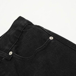 May include: A pair of black denim jeans featuring a classic five-pocket design, a high waistband with belt loops, and silver-toned metal rivets reinforcing the pocket corners. The fabric has a visible twill texture and sturdy stitching throughout.