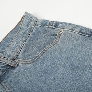 Peut inclure: Un jean en denim bleu clair dot&eacute; d'une coupe classique &agrave; cinq poches, d'une fermeture &agrave; bouton m&eacute;tallique, d'une petite poche gousset et de coutures apparentes. La ceinture comporte des passants et une &eacute;tiquette de marque rectangulaire.