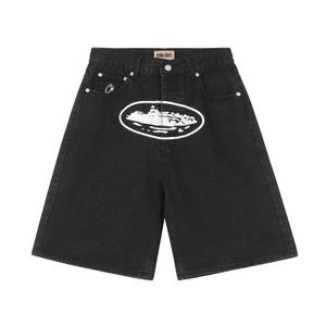May include: Black denim shorts featuring a high-waisted cut, a button and zipper fly, and silver-tone rivets. A large white oval graphic depicting a ship is centered on the front. A small white star logo is on the coin pocket, with a Denim Genes label.