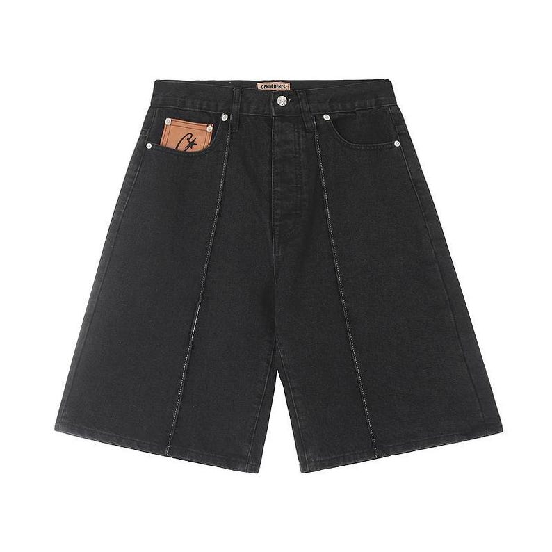 May include: Black denim shorts featuring a high-waisted design with a button fly closure. The shorts include vertical white contrast stitching down the front, silver-tone rivets, and a tan leather-like patch with a black logo inside the pocket.