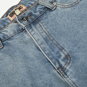 Peut inclure: Un jean en denim bleu clair dot&eacute; d'une coupe classique &agrave; cinq poches, d'une fermeture &agrave; bouton m&eacute;tallique et de passants de ceinture. Une &eacute;tiquette de marque en similicuir beige avec le texte DENIM GENES est cousue sur la ceinture int&eacute;rieure.