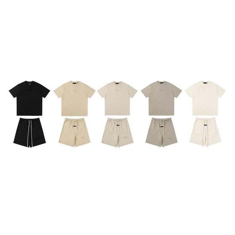May include: Five sets of short-sleeve t-shirts and matching shorts in black, beige, light tan, heather gray, and off-white. Each set features a crew neck t-shirt and shorts with an elastic waistband, long drawstrings, and a small rectangular label.