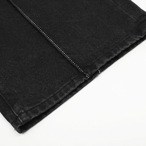 May include: A pair of black denim pants featuring a straight-leg cut and a prominent vertical seam running down the front of the leg. The fabric has a visible twill texture with clean, finished edges at the hem and a single row of white stitching.
