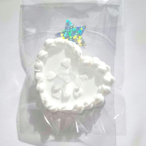 May include: A white, heart-shaped trinket dish with a floral design, packaged in a clear plastic bag. A holographic star is attached to the top of the dish. The dish has a textured, cloud-like border.