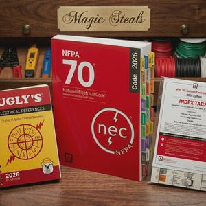 May include: An assortment of electrical reference materials, including a red "NFPA 70 National Electrical Code" book, a spiral-bound "Ugly's Electrical References" book, and index tabs. The books are on a wooden surface, with tools and spools of wire in the background.