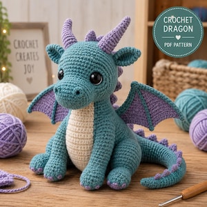 Peut inclure: Un jouet dragon au crochet bleu sarcelle et violet avec de grands yeux noirs, un ventre crème et de petites cornes. Le dragon a des ailes et une longue queue avec des pointes violettes. Une étiquette indique CROCHET DRAGON PDF PATTERN.