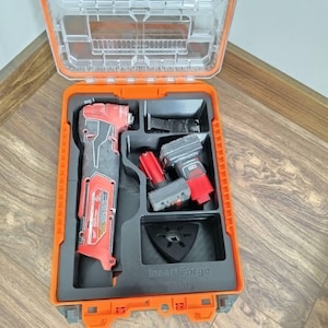 May include: An open orange and clear plastic tool case with a red and black oscillating multi-tool and other tools. The case is on a wooden surface. The text "Insert Forge Tools" is visible.