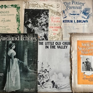 May include: A collection of vintage sheet music covers featuring images of a woman in a forest, a church in a valley, and a woman in a cowboy hat. The titles of the sheet music include "Woodland Echoes", "The Little Old Church in the Valley", and "Where the Sunry Colorado Wends His Way".