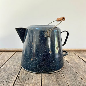 May include: A vintage blue enamel camping coffee pot with a wooden handle. The pot has a speckled blue and white enamel finish.
