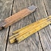 May include: Two vintage wooden folding rulers. The top ruler is closed and the bottom ruler is open, showing the numbers 1 through 30.