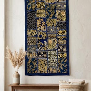 May include: A rectangular wall hanging featuring a patchwork design of dark blue fabric squares. Each square is decorated with intricate gold-colored embroidery, metallic thread work, and sequins in various floral and geometric patterns.