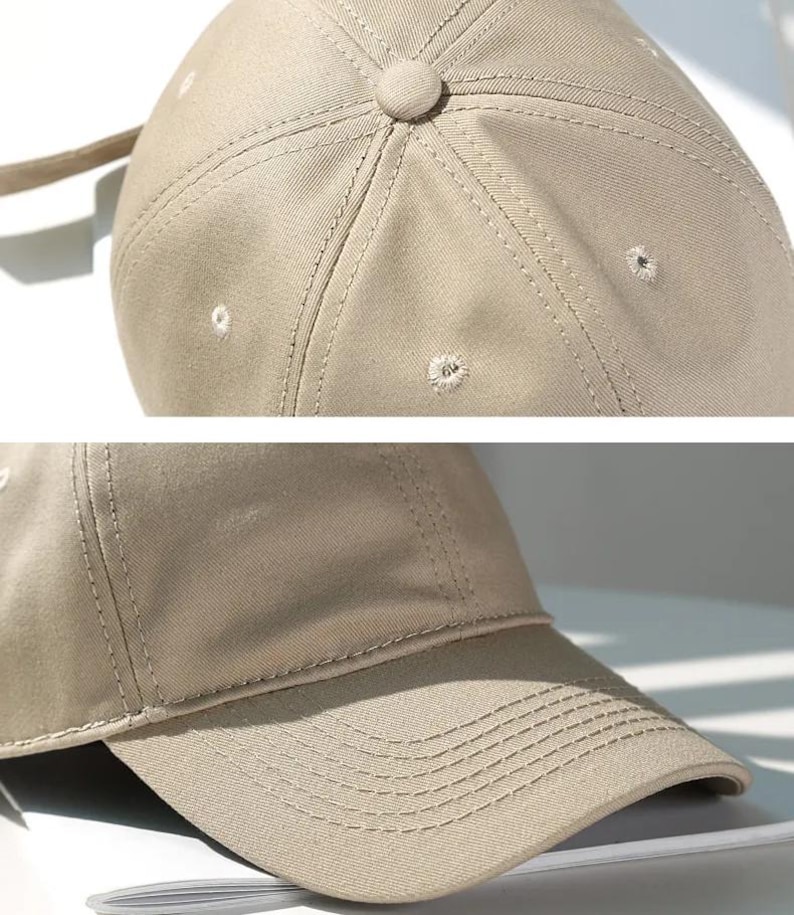 May include: Close-up of a tan baseball cap. The cap features a curved brim and a button on top. The stitching is visible, and there are small ventilation holes. The fabric appears to be a sturdy cotton or similar material.