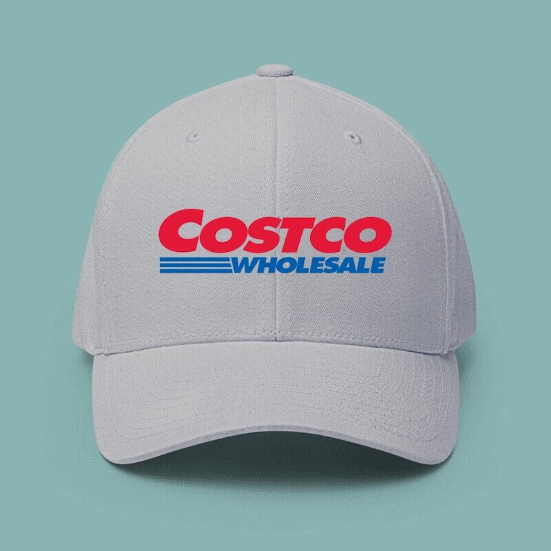 May include: A light gray baseball cap with the Costco Wholesale logo in red and blue. The hat has a curved brim and a structured crown. The text "COSTCO" is in a bold, red font, with "WHOLESALE" in blue below.