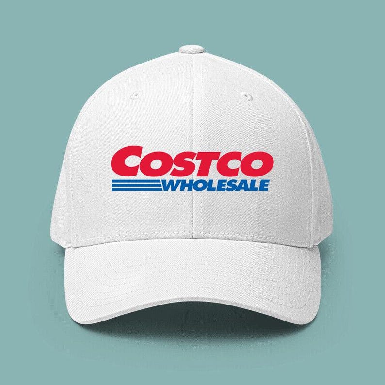 May include: White baseball cap featuring the Costco Wholesale logo in red and blue. The logo is prominently displayed on the front of the cap. The cap has a curved brim and a button on top.