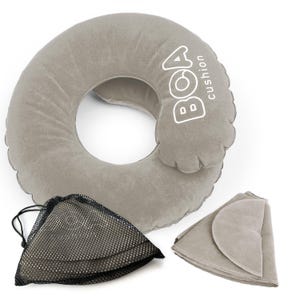 May include: A gray inflatable travel pillow with the word "BOA" and "cushion" printed in white. Includes a black mesh storage bag and a folded gray cover. The pillow is designed for neck support.