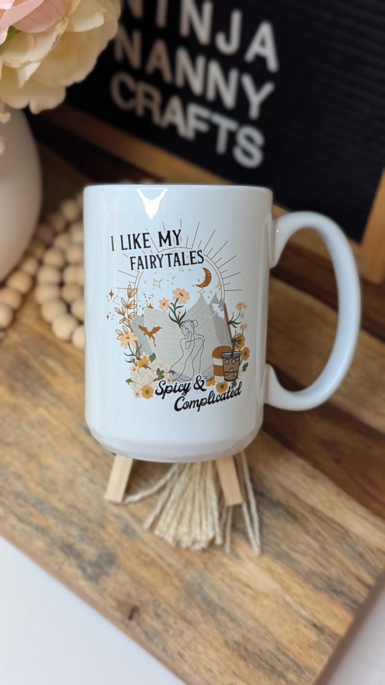 May include: White ceramic mug with a black and gold design. The mug has a quote that reads "I like my fairytales spicy & complicated".