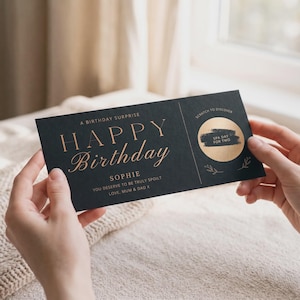 Może przedstawiać: Prostokątna czarna kartka urodzinowa z miedzianym tekstem o treści A BIRTHDAY SURPRISE HAPPY Birthday SOPHIE YOU DESERVE TO BE TRULY SPOILT LOVE, MUM & DAD X. Zawiera okrągłe złote pole do zdrapania z napisem SCRATCH TO DISCOVER.