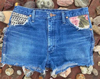 Reworked Distressed Wrangler cutoff shorts with hand printed and vintage floral fabric overlay embellishments on front pockets