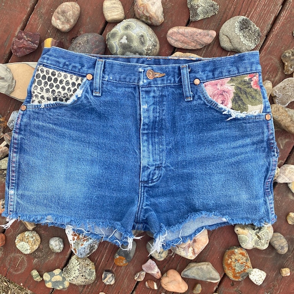 Reworked Distressed Wrangler cutoff shorts with hand printed and vintage floral fabric overlay embellishments on front pockets