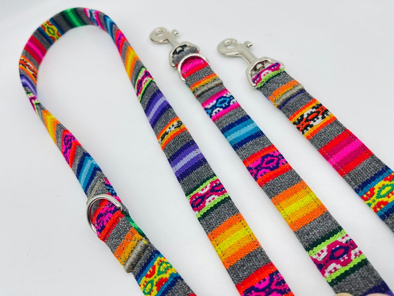 May include: Three colorful dog leashes with grey backgrounds and silver clips. The leashes have a woven pattern with bright colors like pink, orange, yellow, green, and blue.