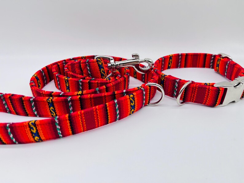 May include: Red and yellow striped dog collar and leash set with a silver clasp.