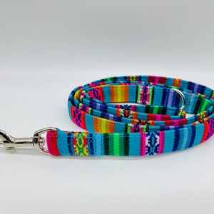 May include: A blue and multicoloured patterned dog lead with a silver clip.