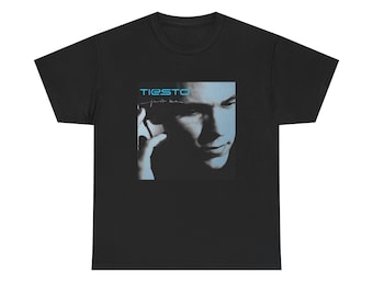 May include: A black short-sleeve t-shirt featuring a square graphic print on the chest. The print displays a blue-toned portrait of a person wearing headphones with the text TIESTO and Just Be printed in a light blue and white font above the face.