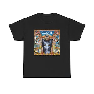 Puede incluir: Una camiseta negra de manga corta con un estampado gráfico central. El diseño muestra la palabra GALANTIS en letras blancas mayúsculas sobre una ilustración estilizada de una criatura oscura con orejas grandes, flanqueada por dos camaleones coloridos.