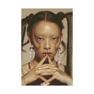 May include: A pair of long, dangling silver-toned earrings featuring a circular top stud and a cascading fringe of clear, sparkling crystals. The earrings hang vertically, catching the light with a reflective, metallic finish and clear stones.