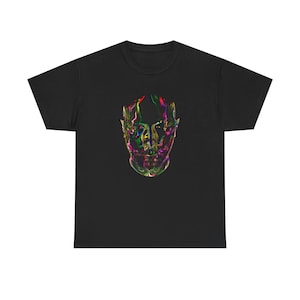 May include: A black short-sleeve t-shirt featuring a central graphic of a human face rendered in a liquid, iridescent style. The face design incorporates vibrant, swirling colors including green, purple, red, and yellow, creating a metallic, reflective appearance against the dark fabric.