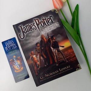 May include: A hardcover book titled James Potter and the Curse of the Gatekeeper by G. Norman Lippert with a dark cover illustration of four figures, accompanied by a matching rectangular bookmark featuring a blue crest and the book title.