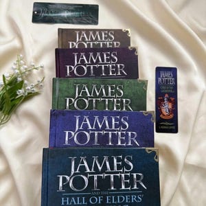 May include: A stack of five hardcover books titled James Potter with metallic corner protectors, accompanied by a matching bookmark and a rectangular label. The book covers are brown, purple, green, blue, and dark blue with silver lettering.