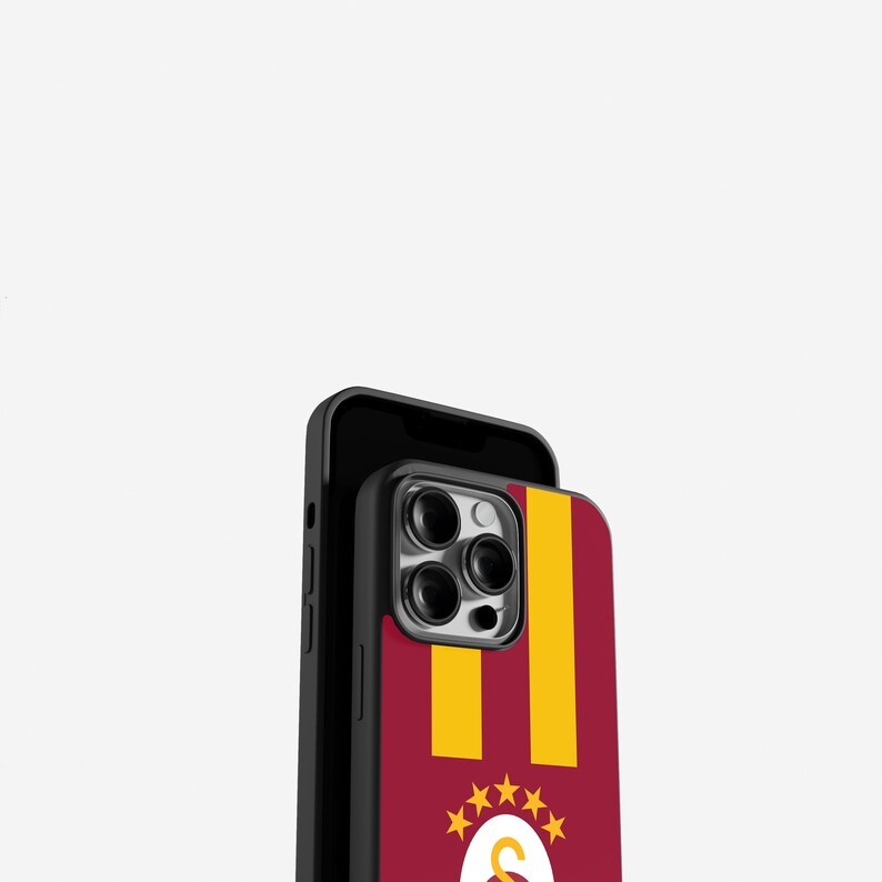 May include: A black phone case with a maroon and yellow design. The case features vertical yellow stripes on a maroon background, with a logo and stars at the bottom. The phone case is designed to fit a smartphone.