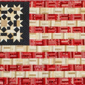 May include: A patchwork American flag quilt with red, white, and blue fabric. The blue section features a star pattern, while the red and white stripes are made of smaller squares.
