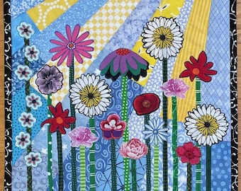 May include: A colorful patchwork quilt featuring a variety of flowers in a garden setting. The quilt is made with different fabrics and patterns, including blue, yellow, green, red, pink, and white. The flowers are arranged in a whimsical and abstract way, creating a cheerful and vibrant design.